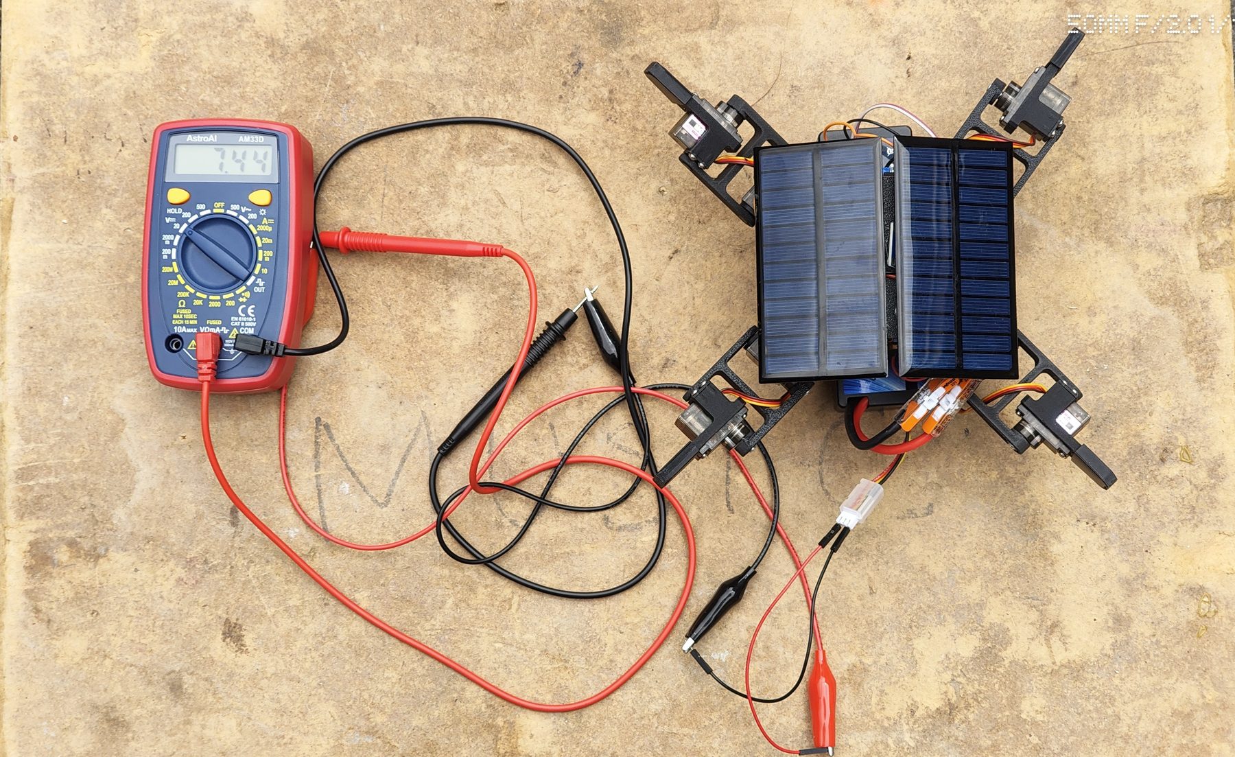 S.O.L.A.R. prototype beside a multimeter during solar power testing.